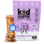 A bag of kid coffee S'mores Latte instant coffee and nutrition powder, shown next to a glass of iced coffee and a stack of s'mores cookies. The packaging is light purple with a cartoon coffee cup character and text highlighting key features.