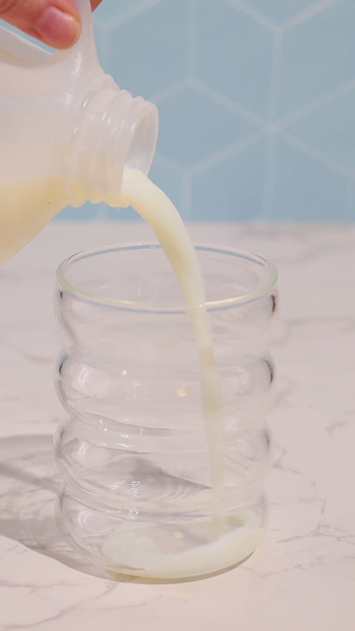 Making kiid coffee in cup. 3 steps pour milk, add kiid coffee, mix and then top with milk