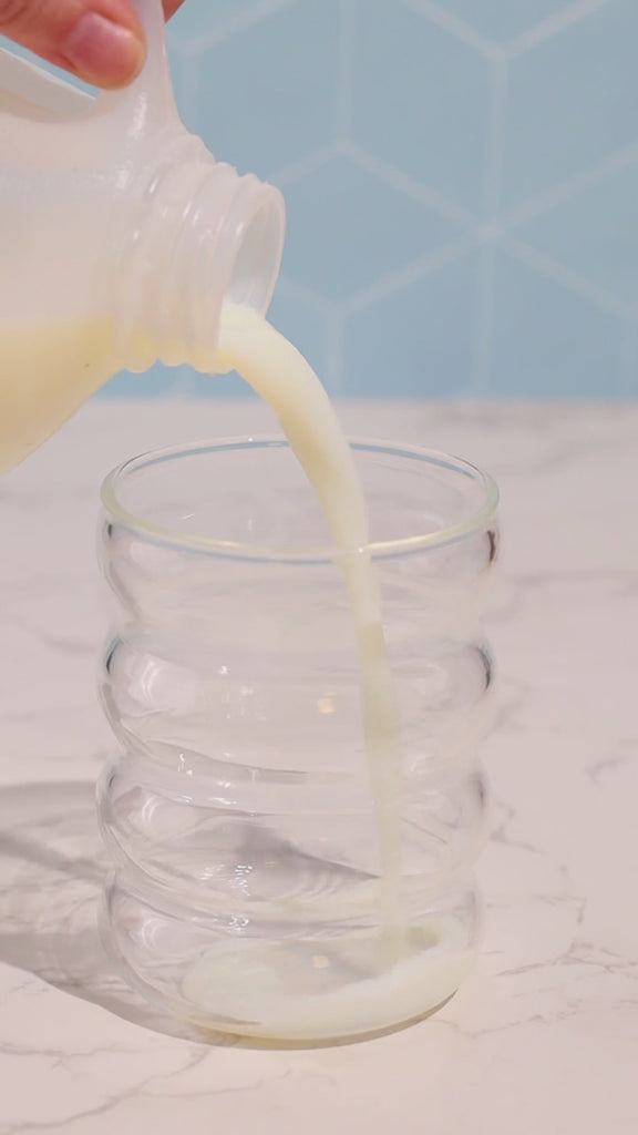 Making kiid coffee in cup. 3 steps pour milk, add kiid coffee, mix and then top with milk